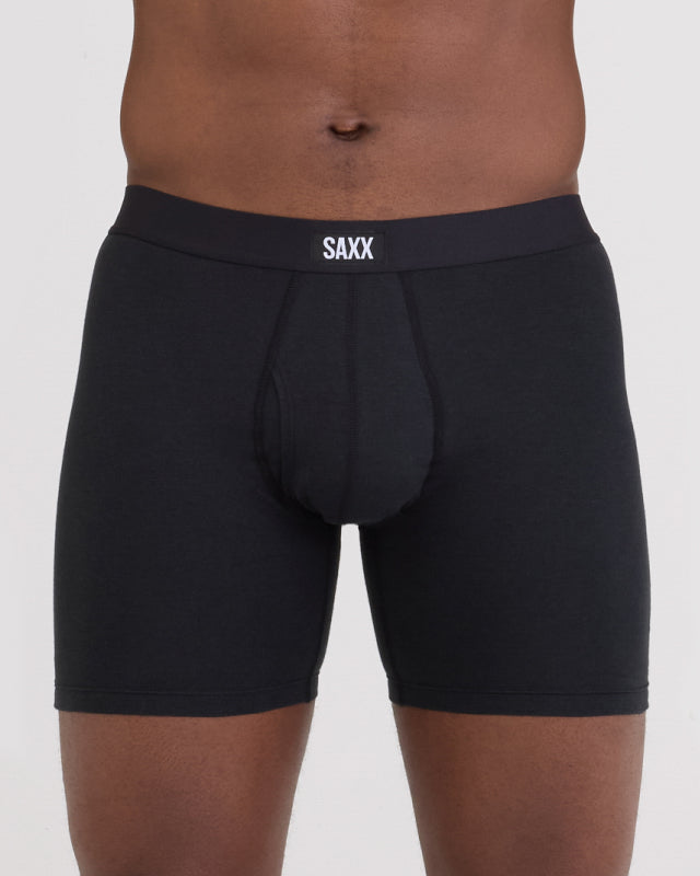 Model wearing black boxer briefs with 'SAXX' branding on a plain background