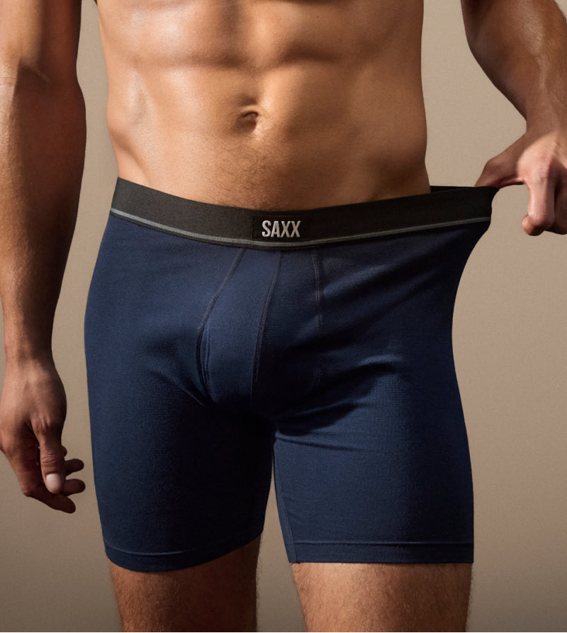 Model wearing navy blue boxer brief stretching waistband