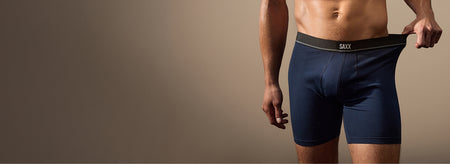 Model wearing navy blue boxer brief stretching waistband