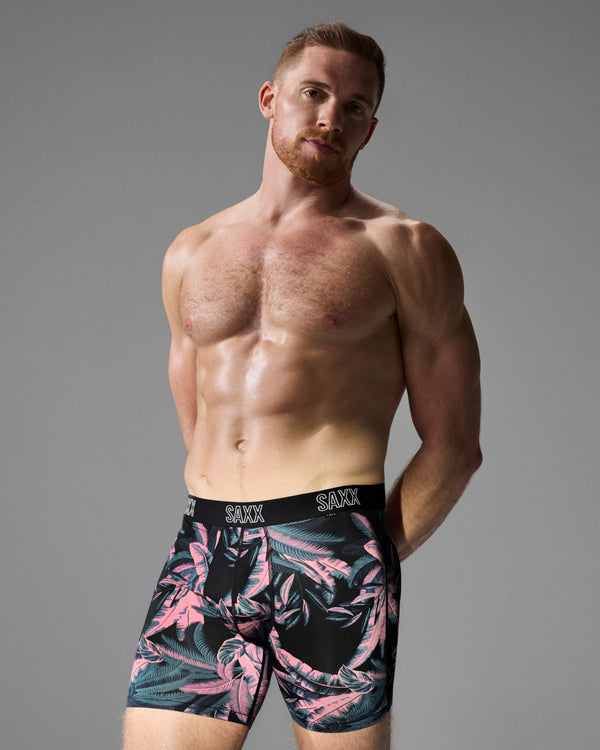 Model poses in SAXX Free DropTemp All Day Cooling Boxer Brief in Tropical Jungle-Black